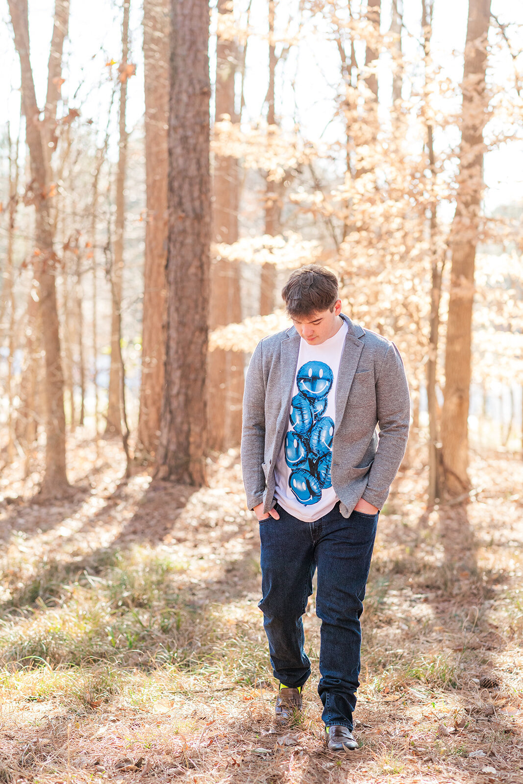 Senior guy portraits surrounded by trees and sunlight