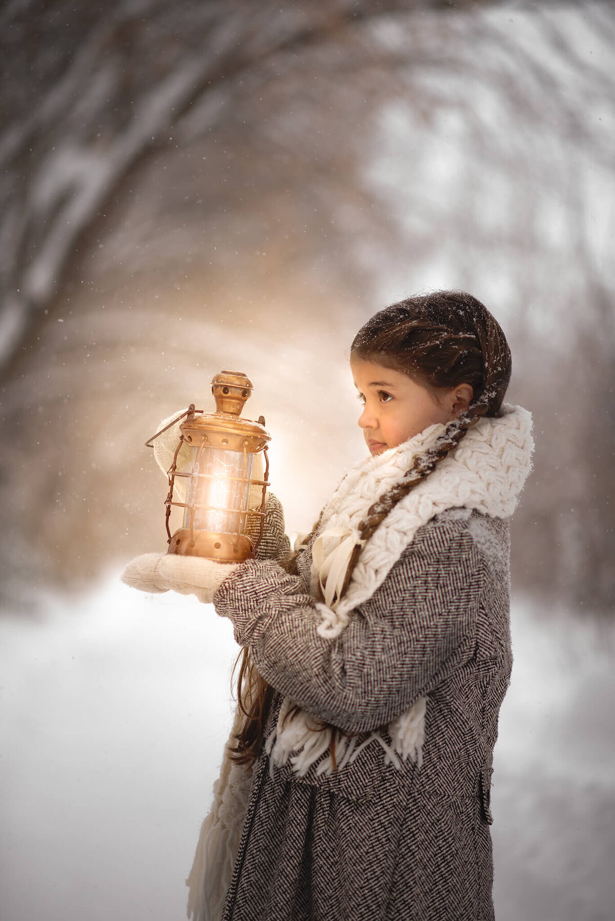Girl with braids holds up a glowing lantern in front of her face in the winter time. Taken in Kamloops by Brittany Danielle
