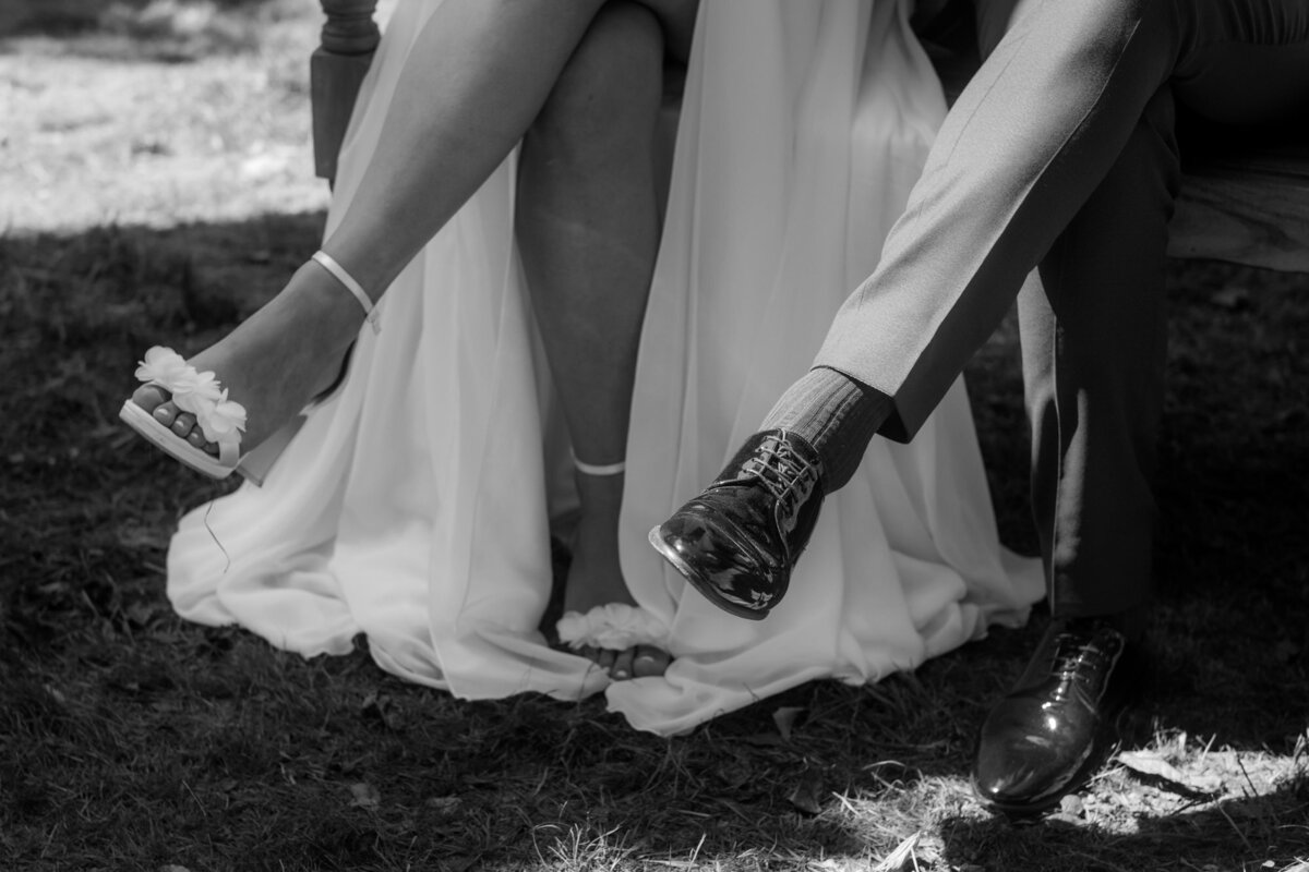 Während der Freien Trauung sitzt das Hochzeitspaar nebeneinander. Eine Nahaufnahme der überkreuzten Beine.