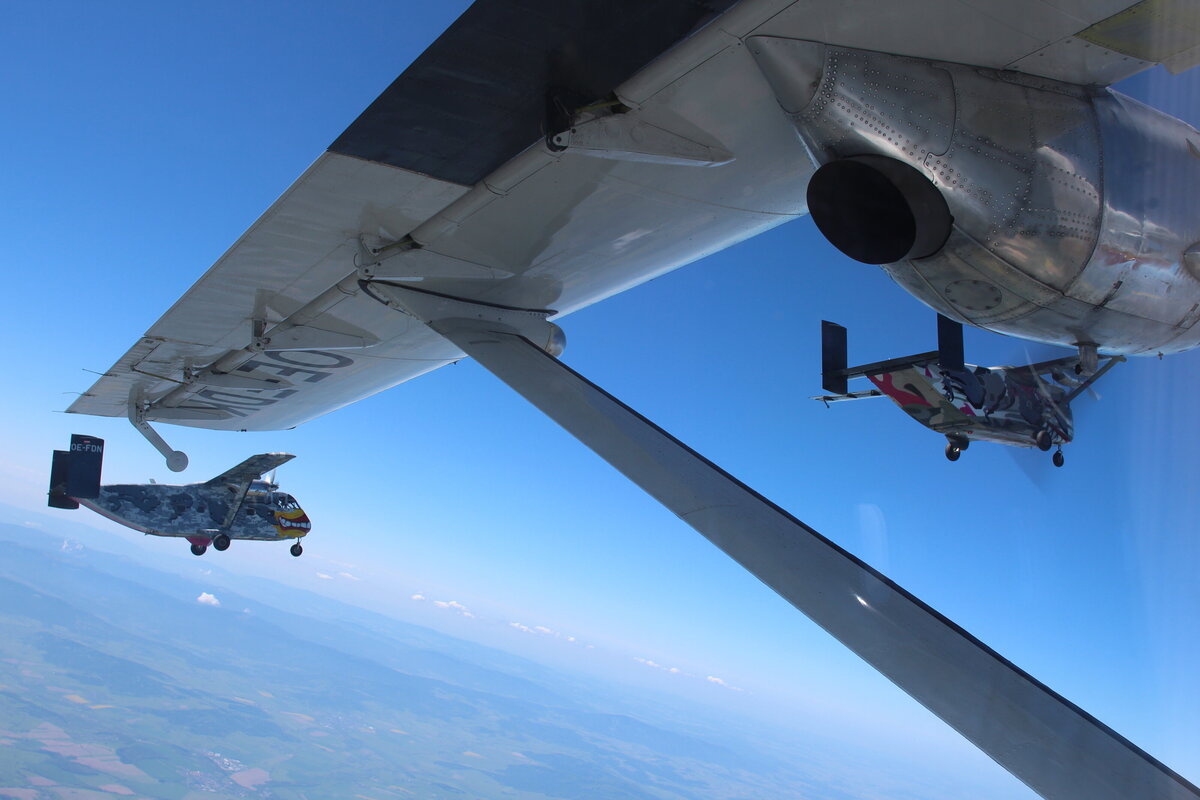 Das Bild ist aus einer Skyvan gemacht. Zu sehen sind zwei weitere Pink Skyvans, die in Formation fliegen