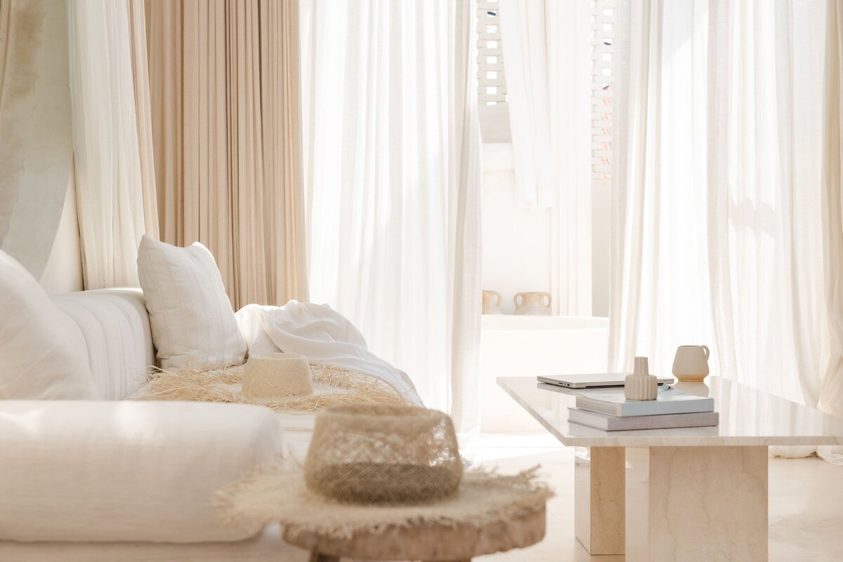 Lifestyle design living room featuring a cream sofa, wooden side table and simple coffee table vignette