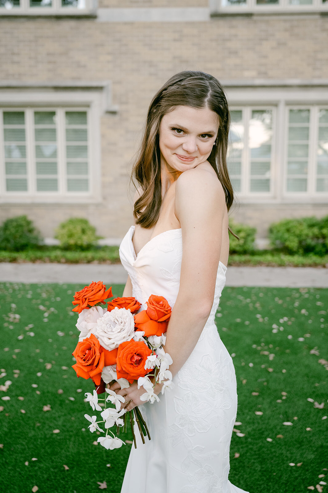 Bride smiling with bold floral bouquet captured outside luxury San Antonio wedding venue