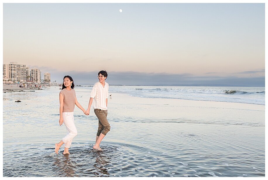engaged couple walking in ocean at coronado san diego