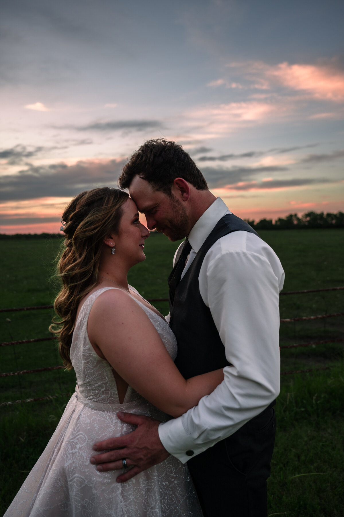 wedding couple standing together with sunset in the background