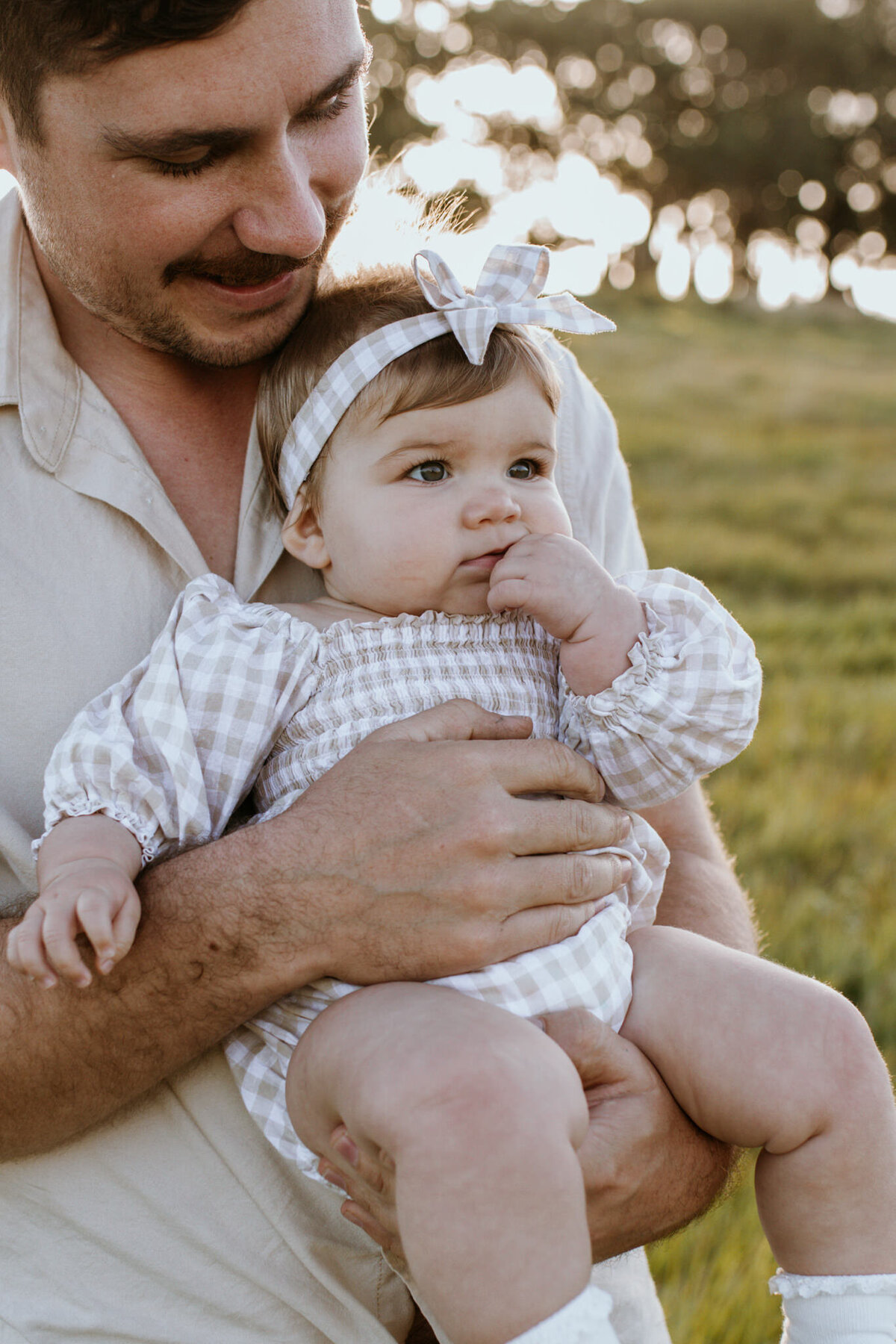 A close-up of Dad and his daughter, as he holds her to his chest.