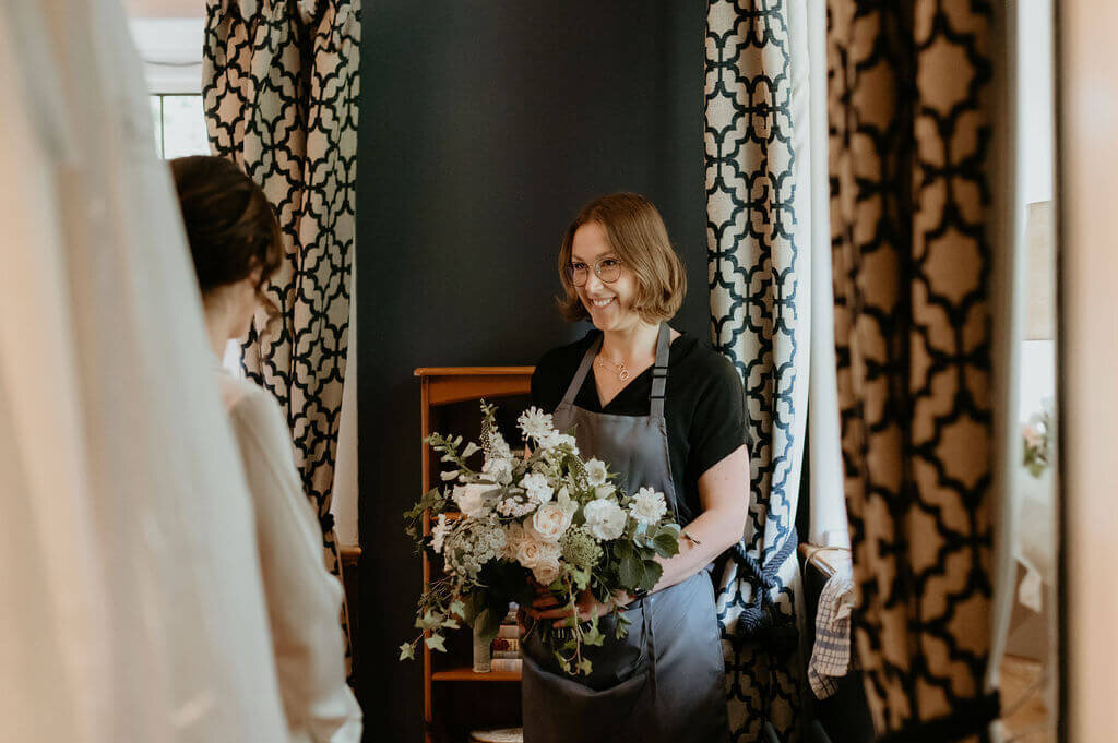 Kelly presenting the bride with her florals
