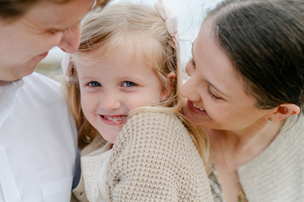 Close up photo of little girl being held by mom and dad