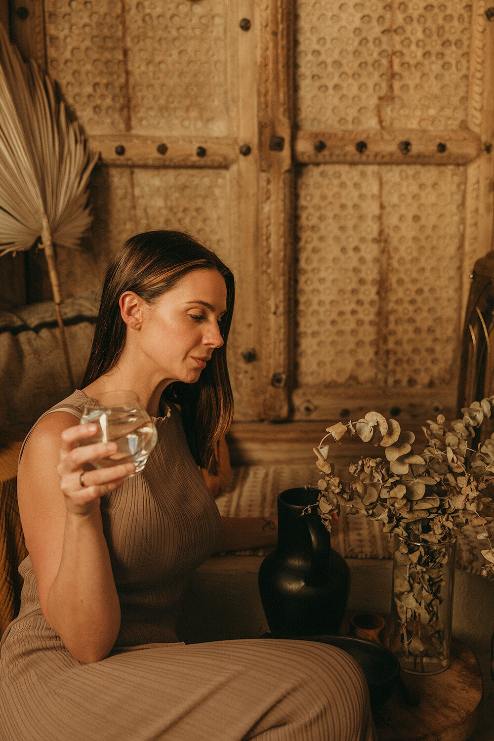 Grounded branding photo of a woman with water, captured in a rustic setting by a Sunshine Coast branding photographer.