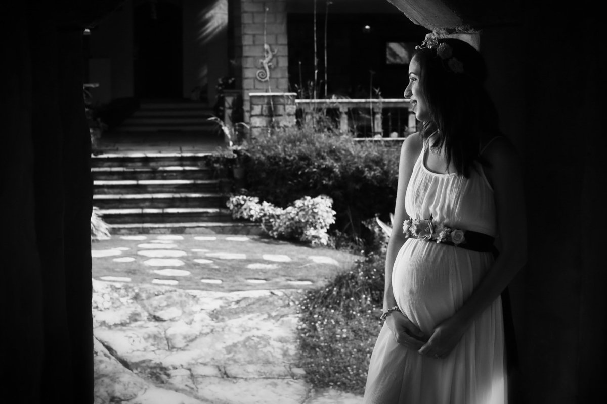 B+W maternity shot of mom in a doorway to a landscaped garden. Photo by Ross Photography, Trinidad, W.I..