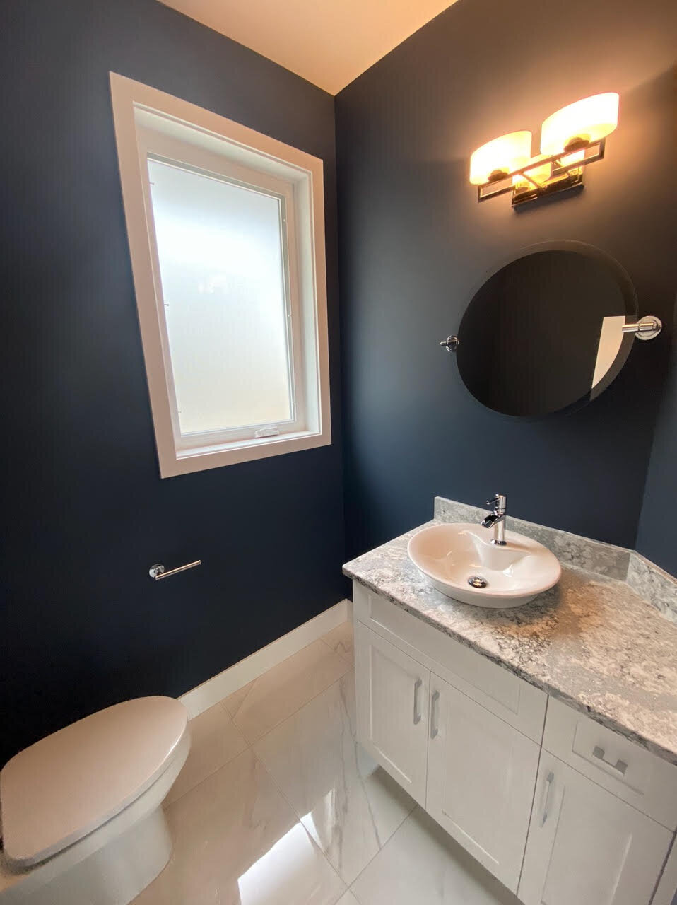 Blue bathroom design with above counter sink and tile floors.