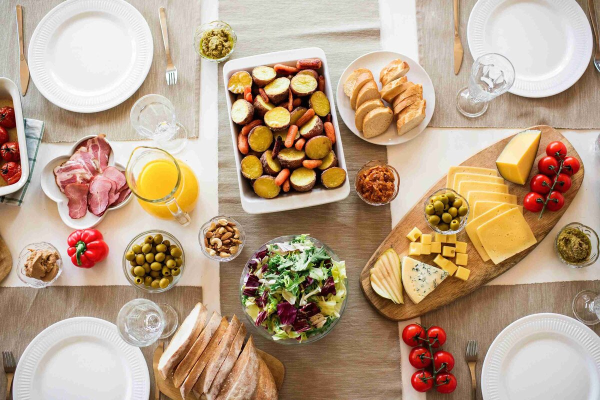 A table set with various plates of food and drinks, showcasing a colorful and appetizing spread for a meal.
