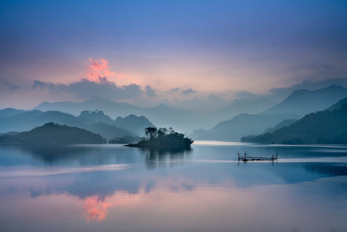 Boat on the water during sunset with mountains in background