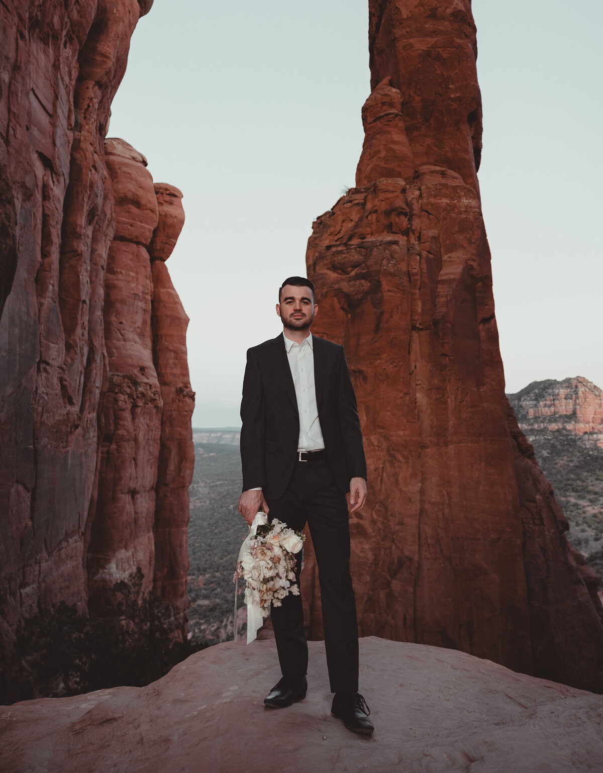 Couple walking along red rock ledge Cathedral Rock Sedona taken by Kollar Photography