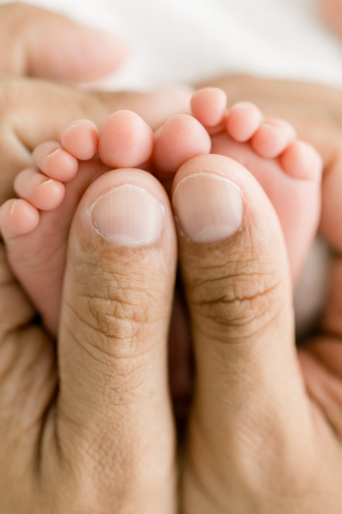 close up of a dad holding a newborn baby's feet