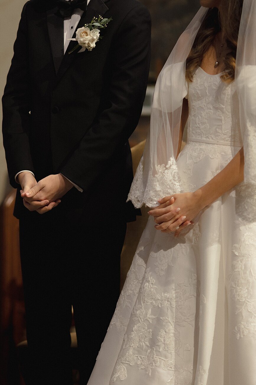 bride and groom hands during church ceremony