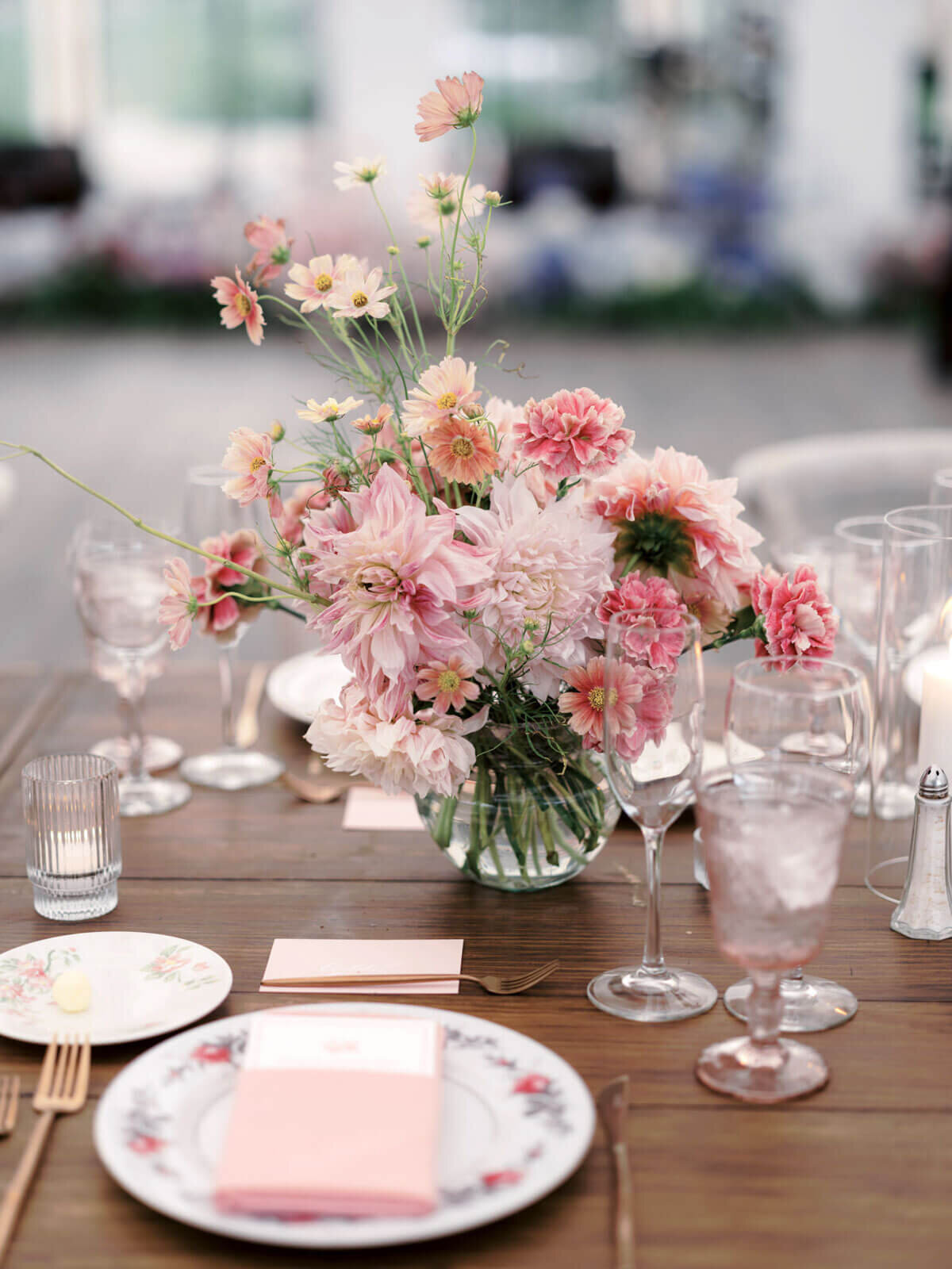 Flowers, napkins, and wine glasses in shades of peach on an elegant wedding reception at The Ausable Club, NY. Image by Jenny Fu Studio