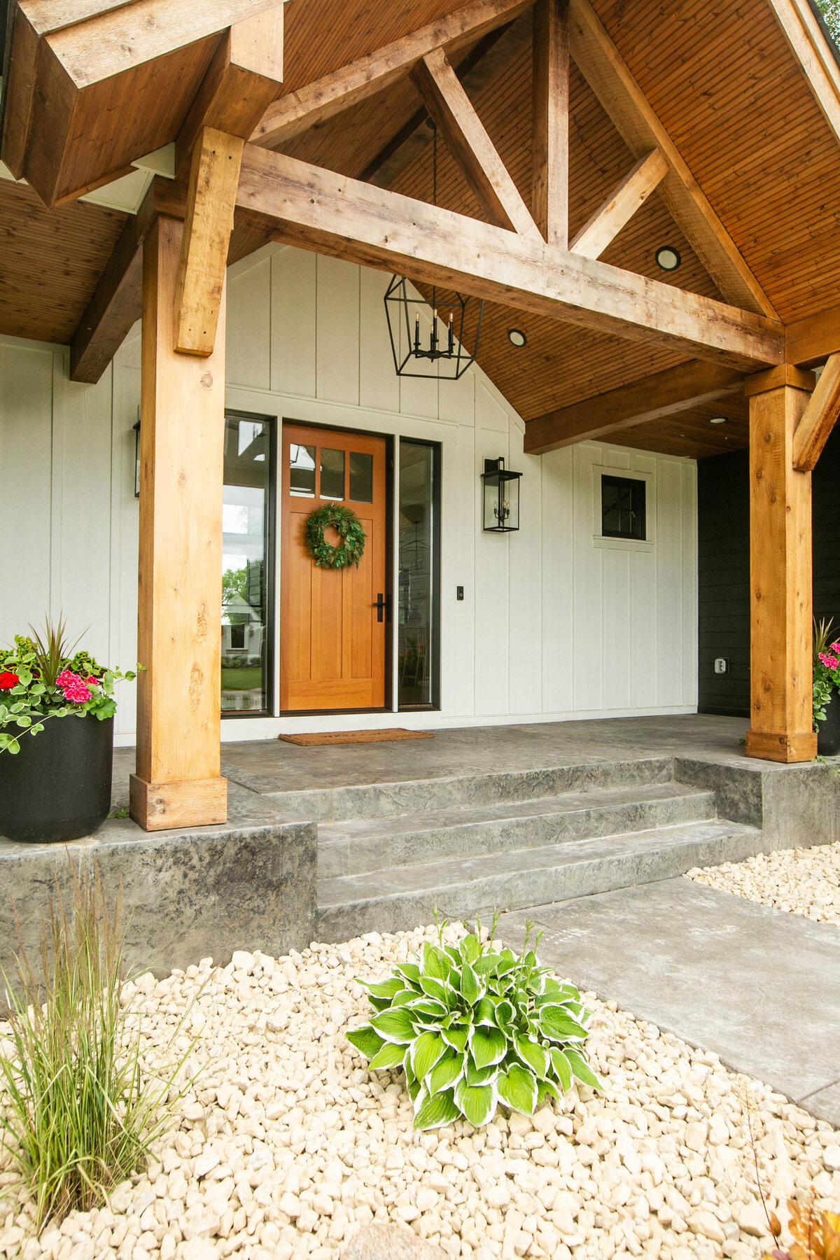 Exterior view of custom home in Otsego, Minnesota with modern wood details and front porch built by Cornerstone Custom Builds