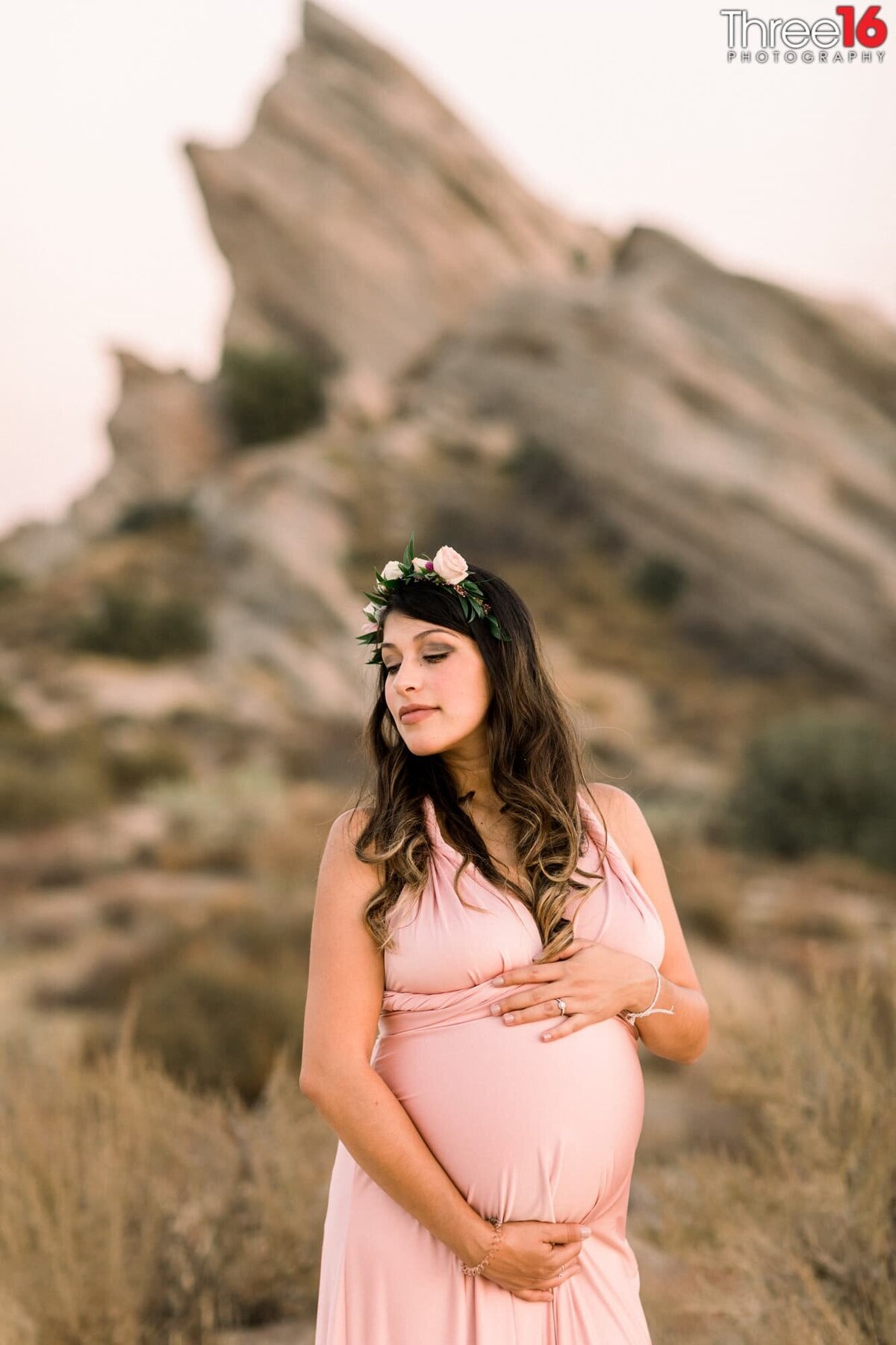 Mom to be poses highlighting her pregnancy during photo session