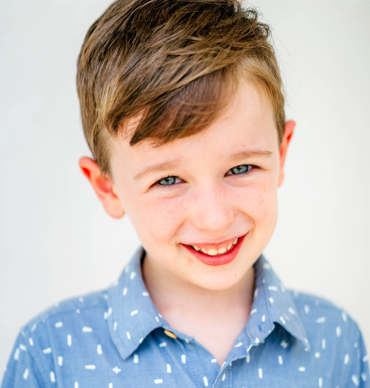 Fine art school photography of boy in relaxed pose, soft lighting, white background