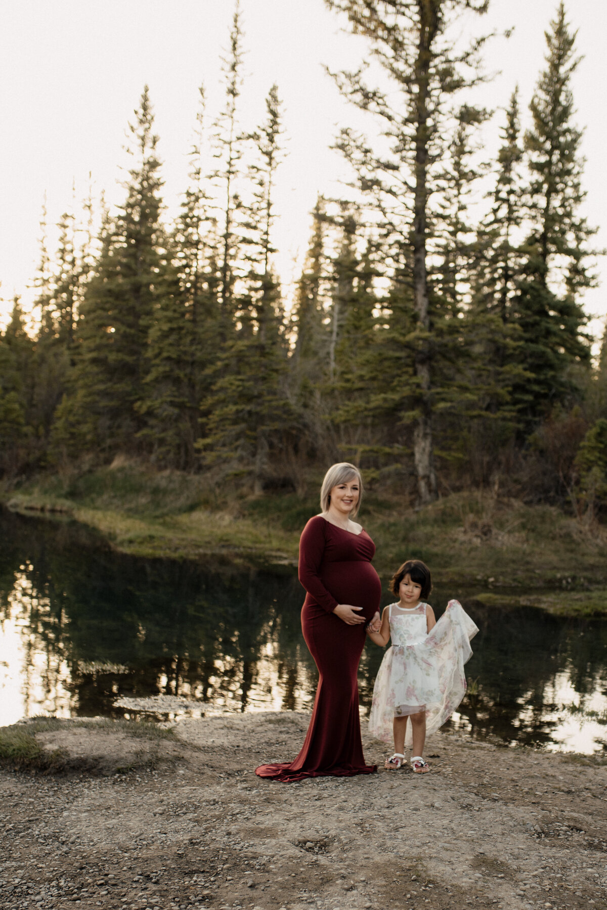 Pregnant woman in red dress and her daughter