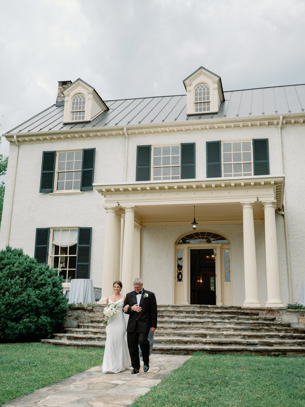 Bride and Father walk out of Rust Manor House to the wedding ceremony