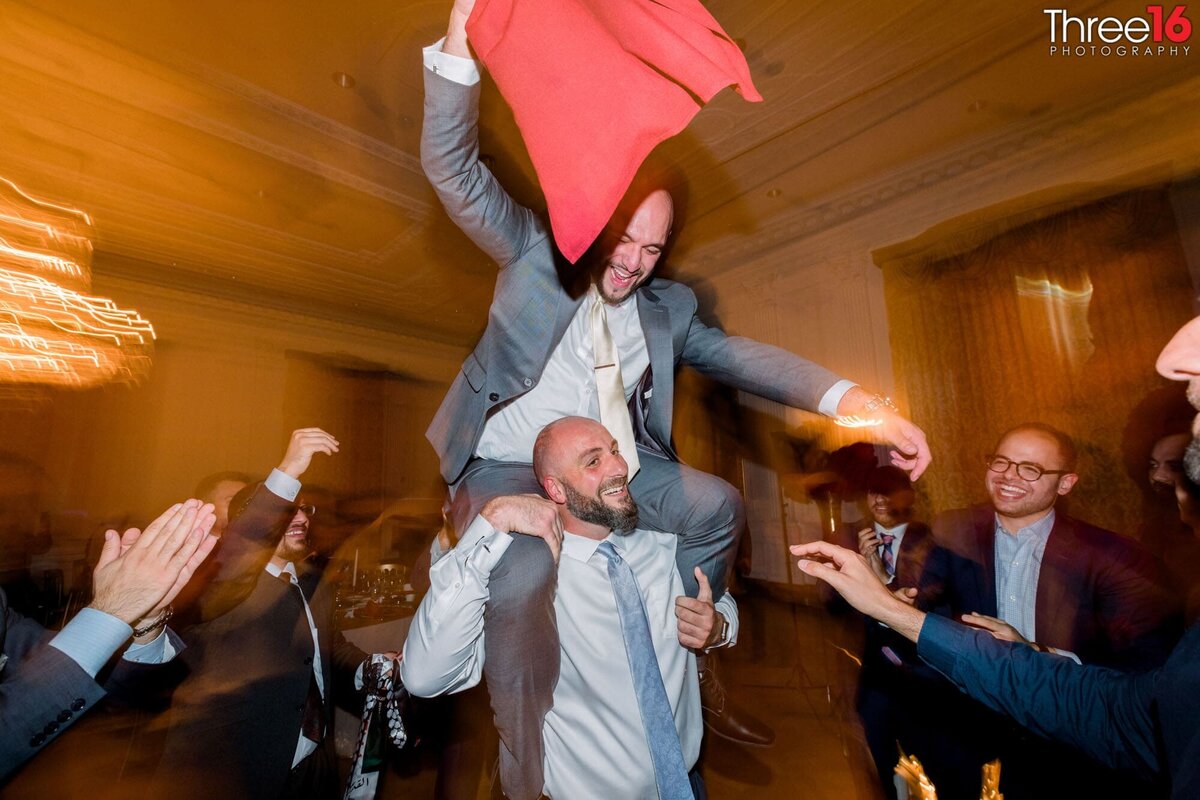 Man climbs on the shoulders of another man during an event dance
