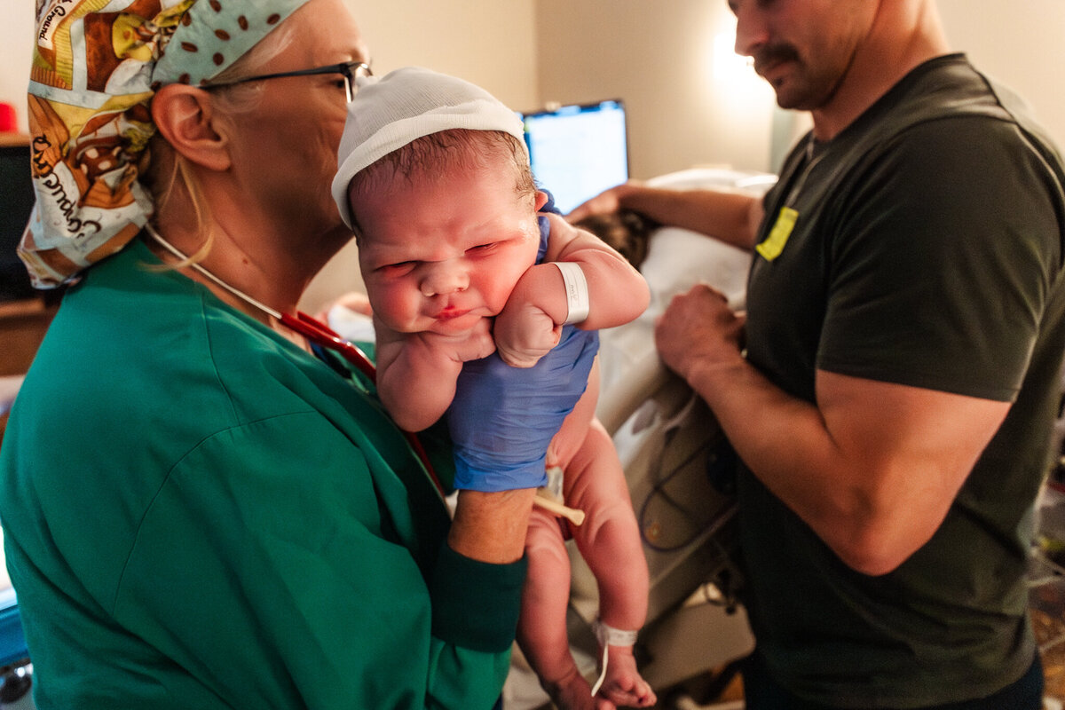 A baby is held up by a nurse in Modesto, California, and the mother was supported by a Modesto Doula, Shayna cox. 
