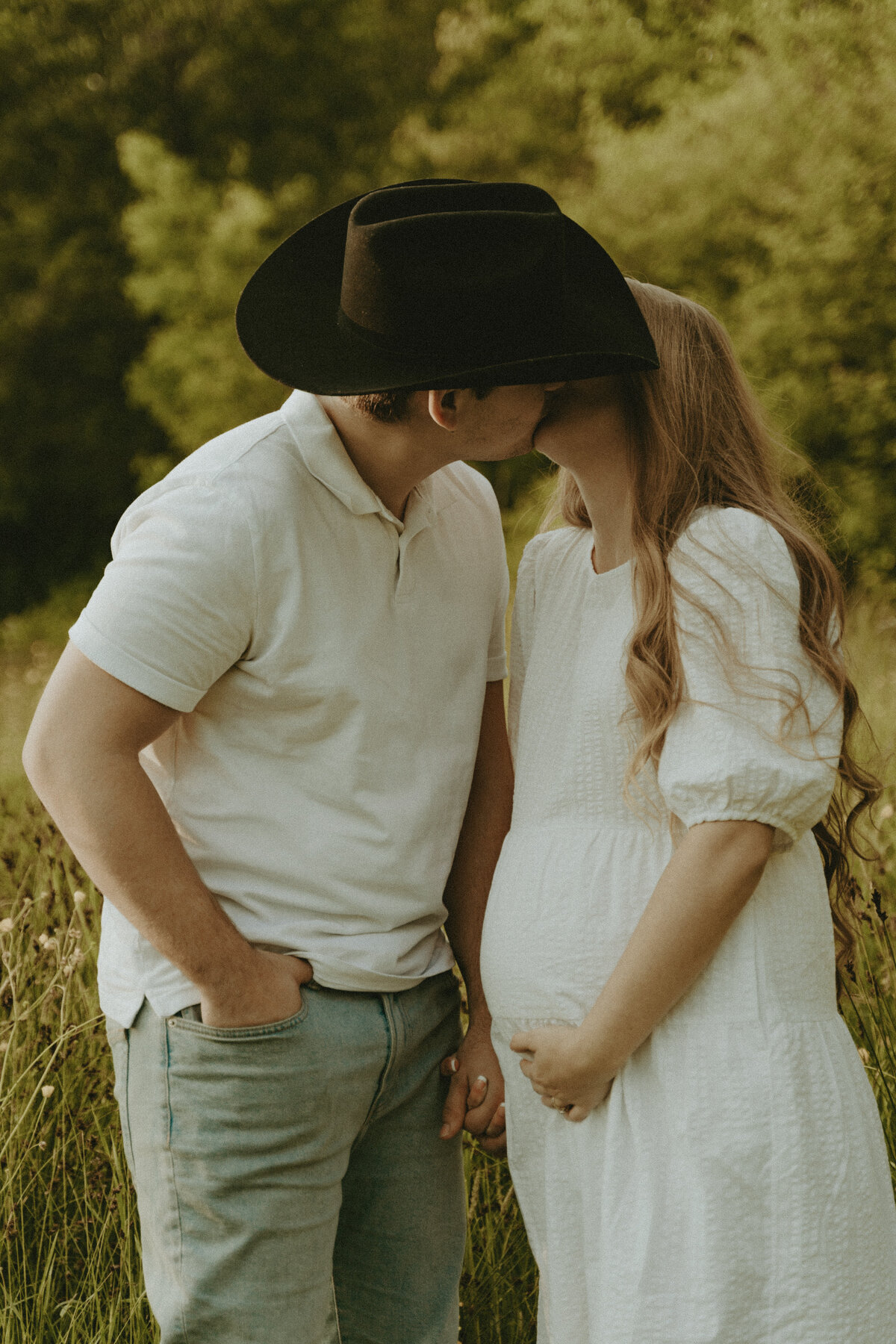 maternity photo of a pregnant mama and a  husband in a cowboy hat