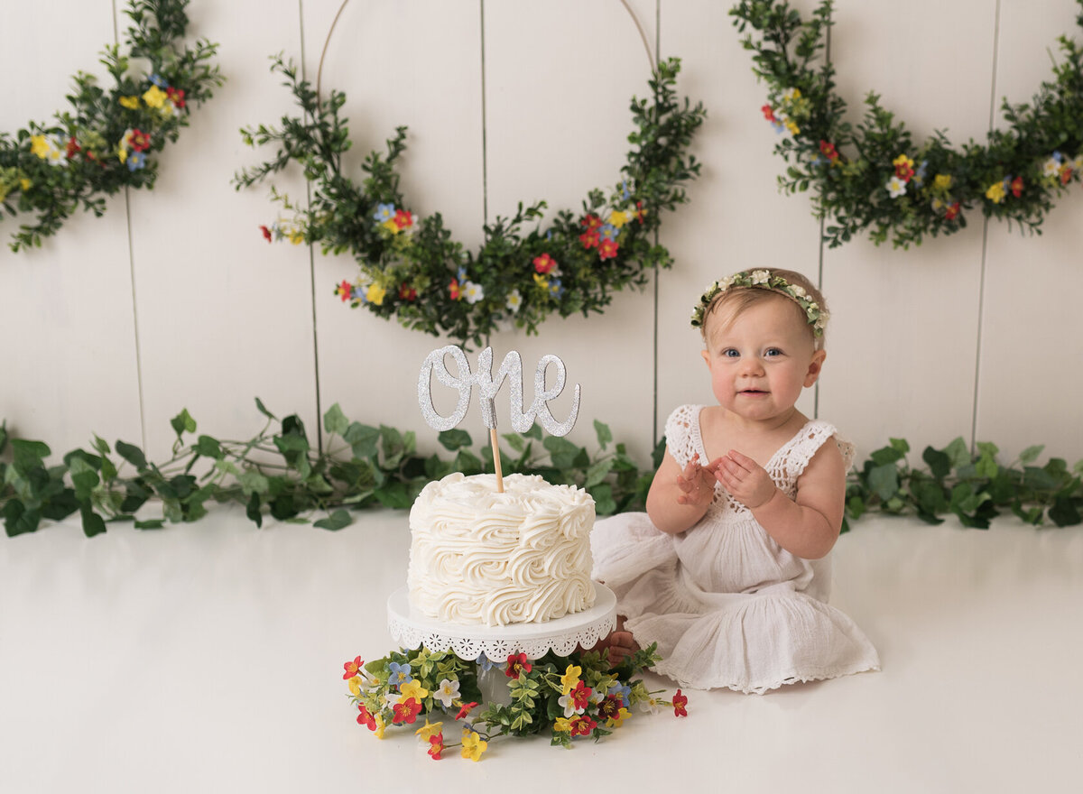 Newborn cake smash portrait in white background with green leaves