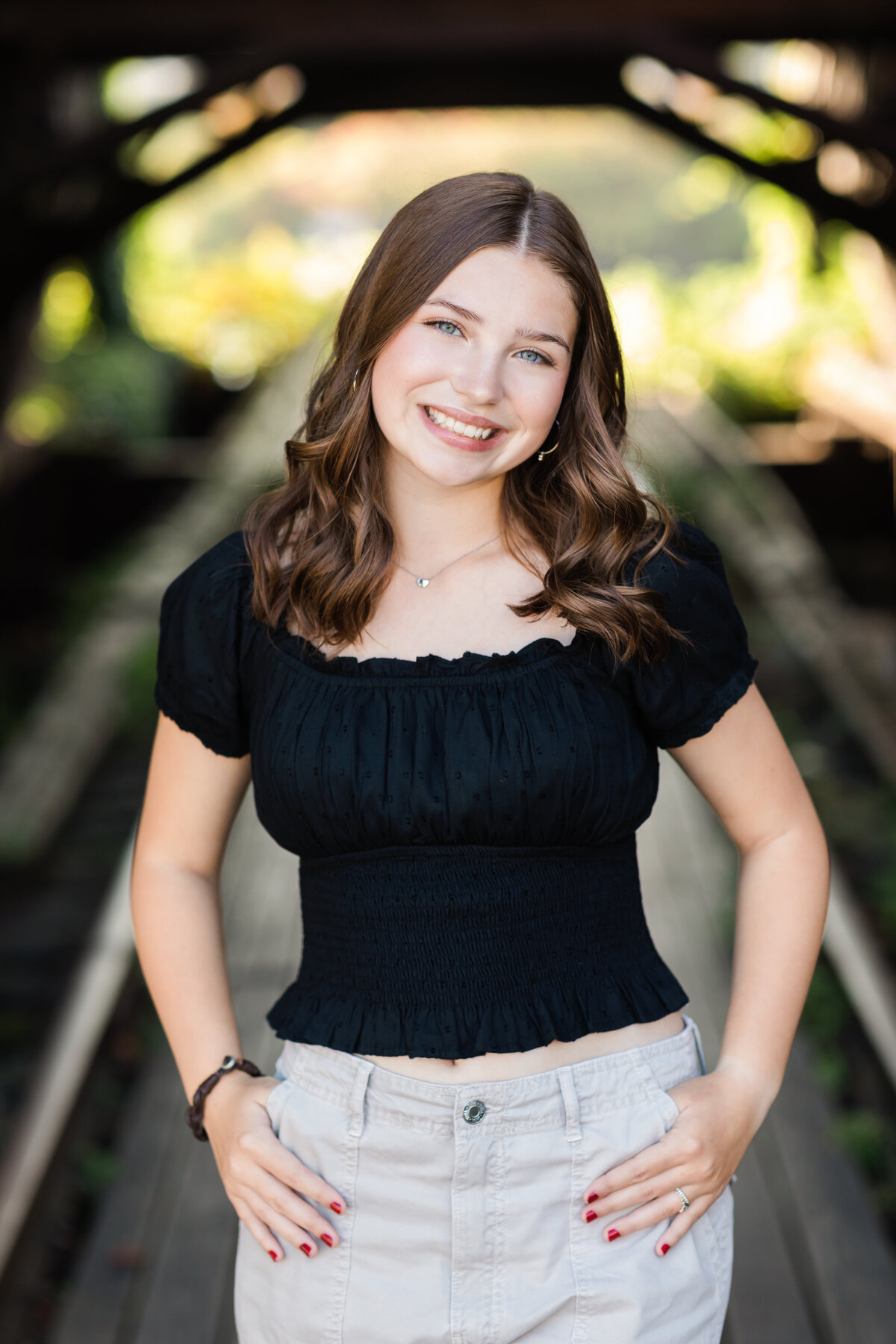 senior girl in black shirt posed at shooters on the water for senior portraits cleveland senior photographer