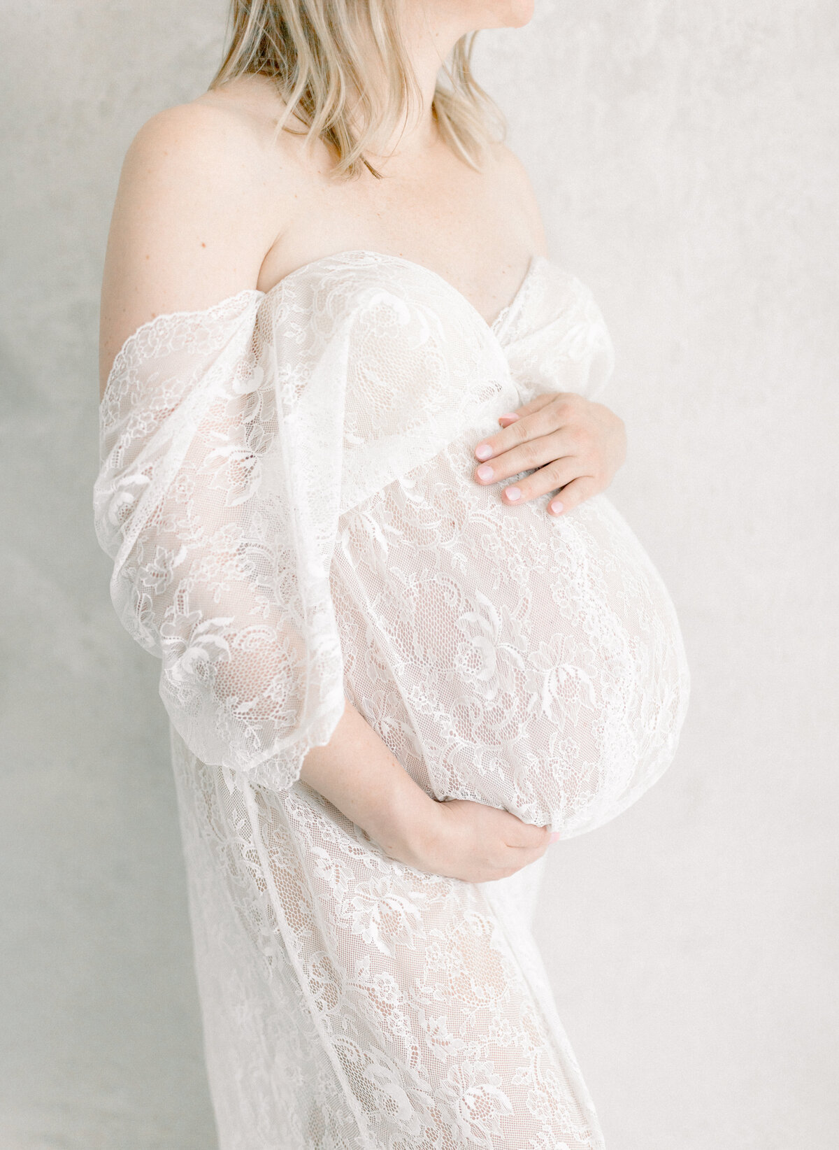 Portrait of an expecting mother in a lace dress