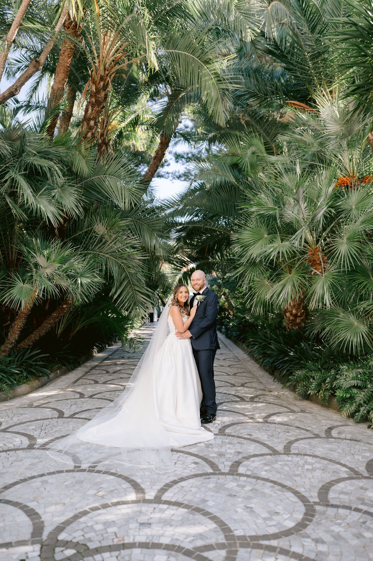 bride and groom amongst the palm trees in the villa silvana gardens