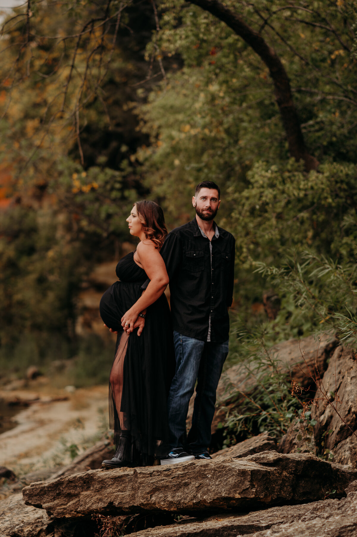 Maternity portrait of woman and her husband on a rock near the water in Stillwater, MN