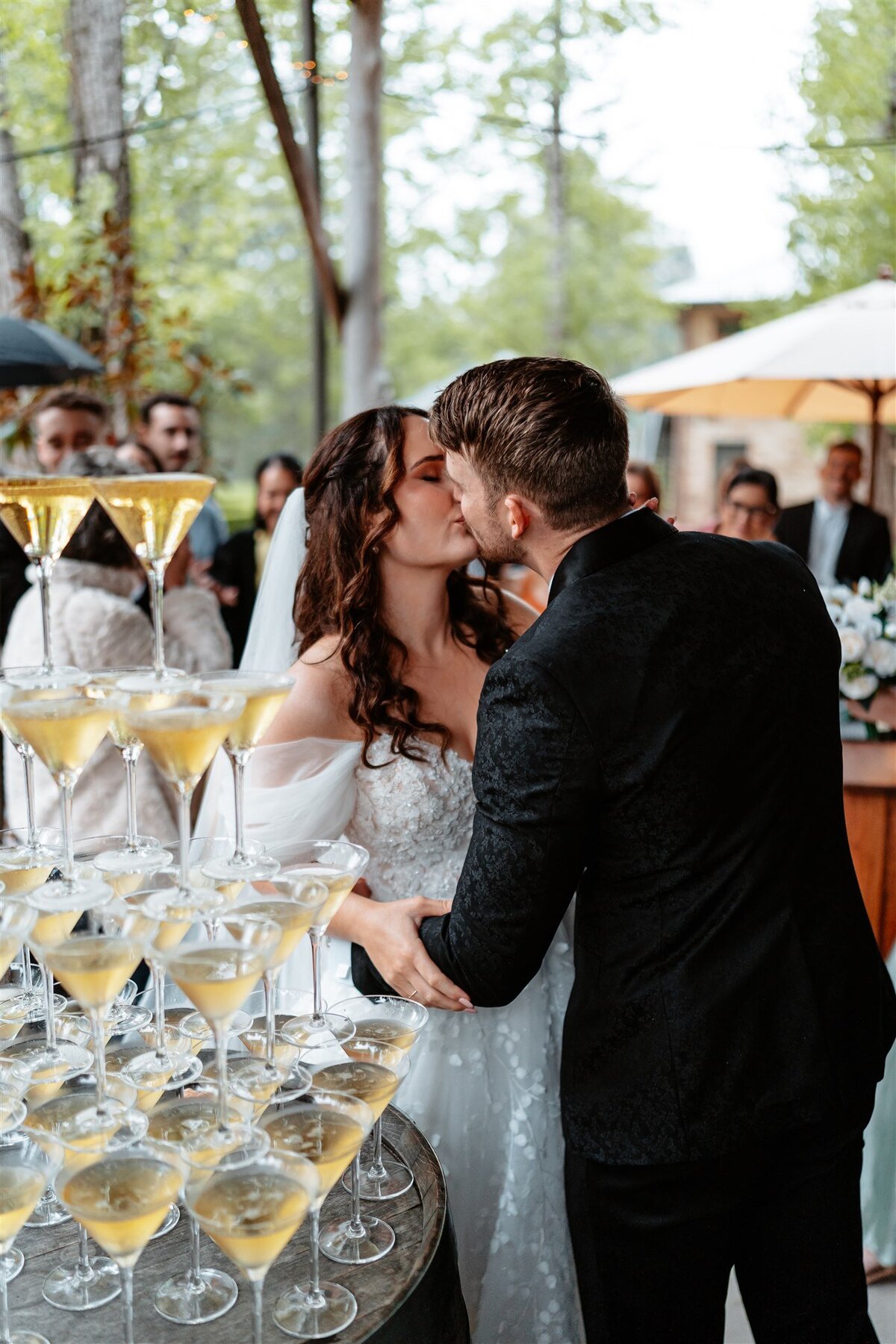 The newlyweds share a tender kiss as they exit the ceremony, radiating love and joy in their post-nuptial bliss.