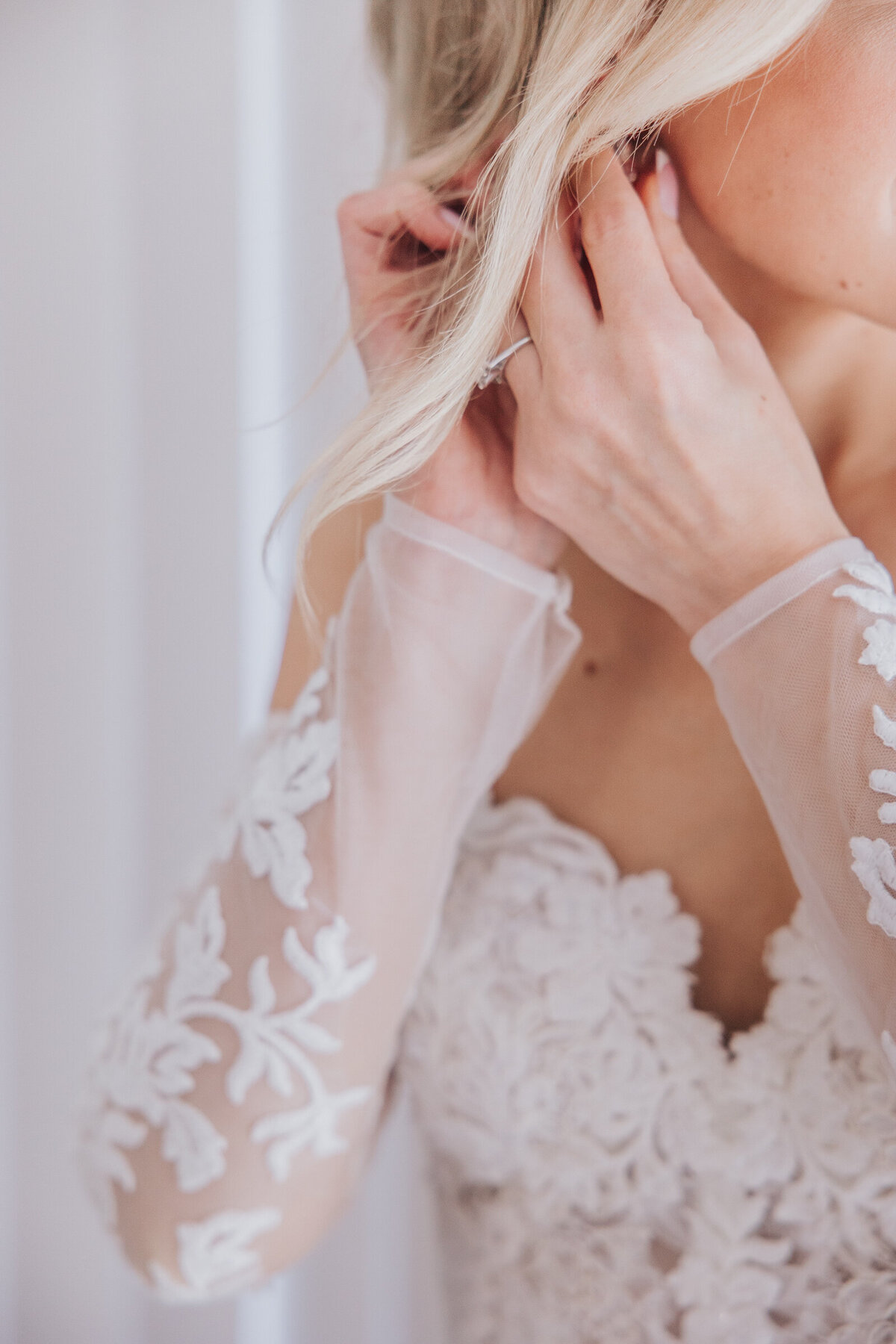 Detail shot of bride putting on jewellery photographed by Nova Markina