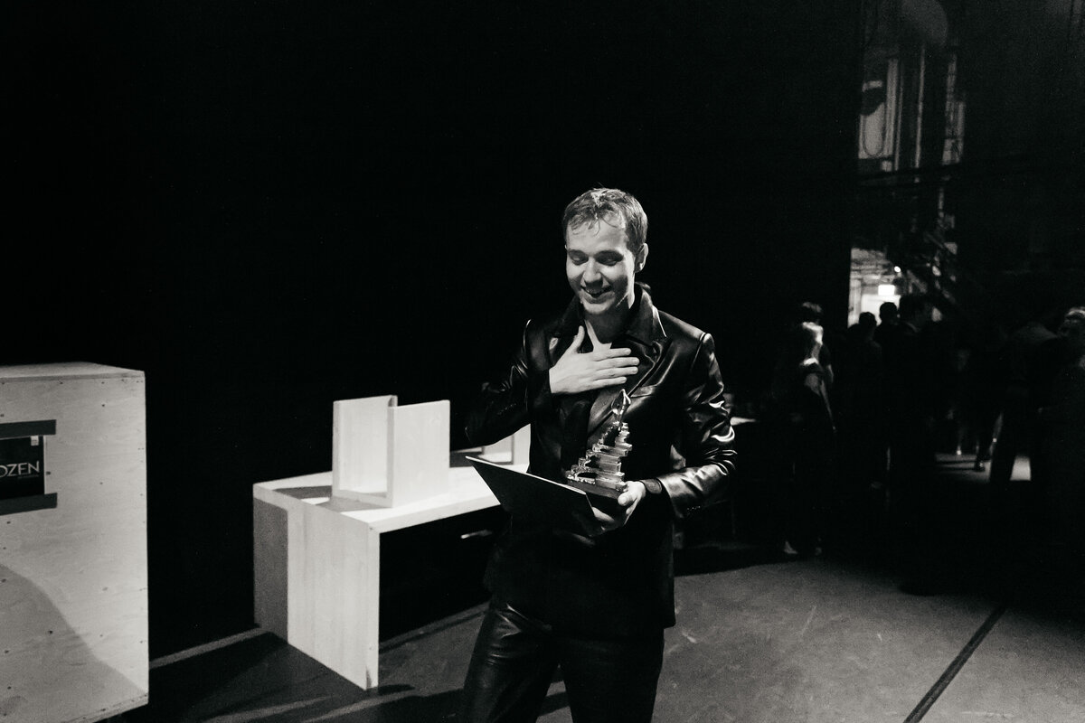 Acteur Martijn Noort met Musical Award in handen in de coulissen.