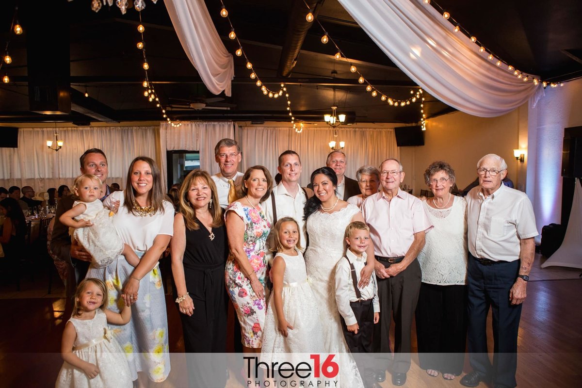 Bride and Groom pose with the family on the dance floor