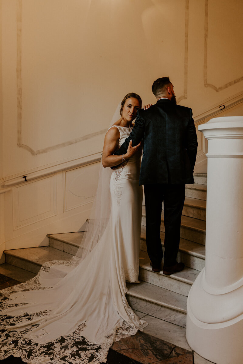 Mariés posant sur les marches en marbre d'un immense escalier lors d'une séanc ephoto mariage en Vendée.