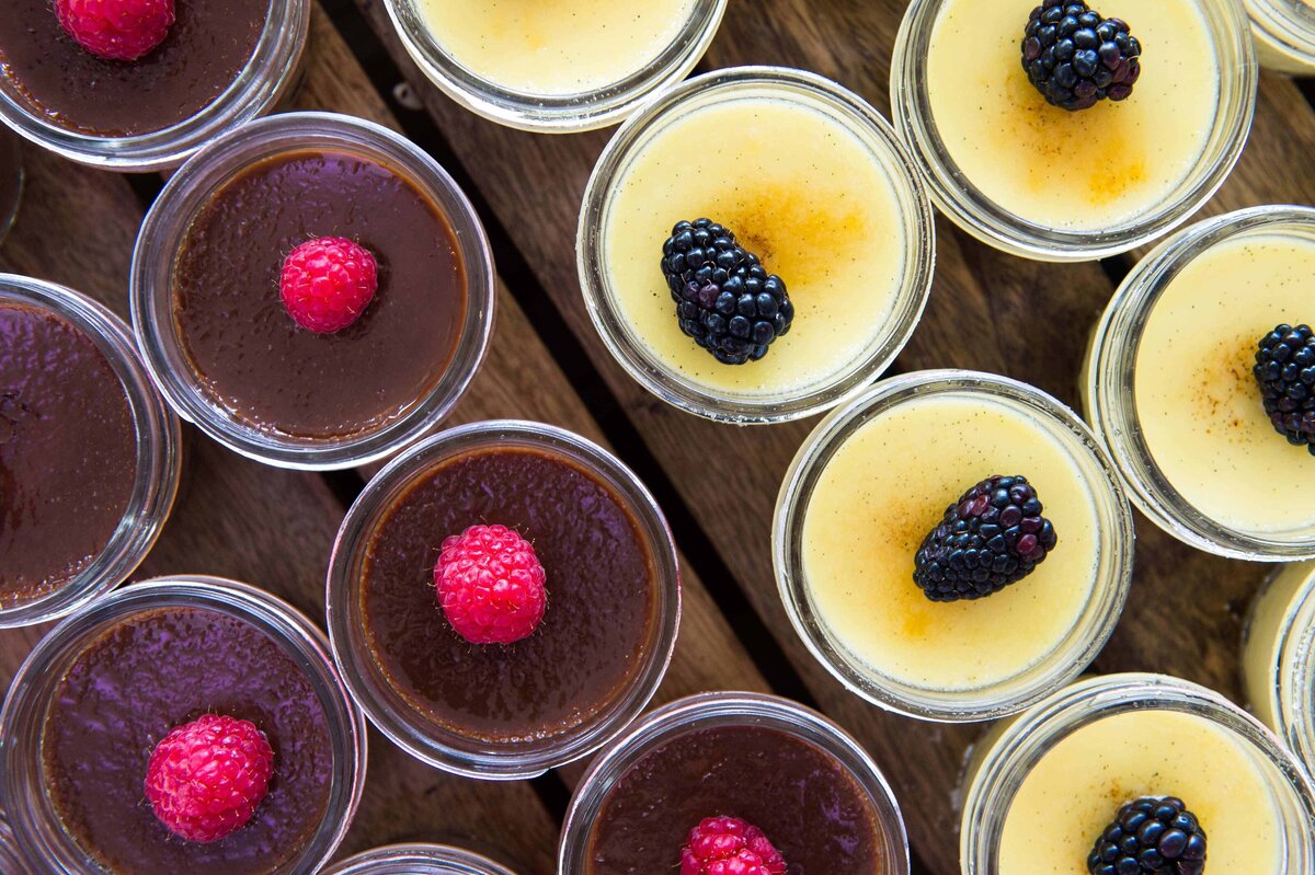 Chocolate and plain flan in mason jars with blackberries and raspberries shot overhead for a banner for marketing collateral