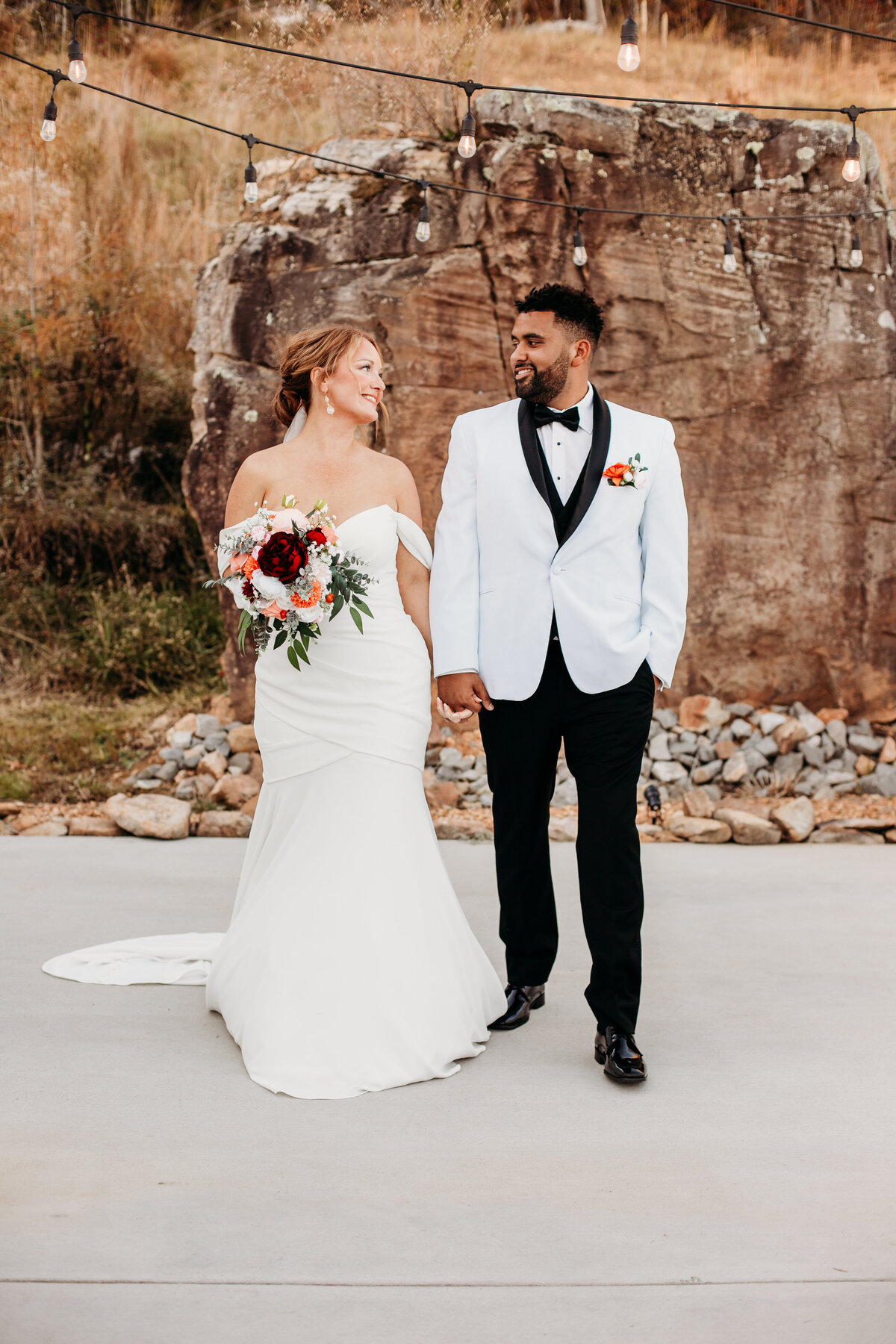bride and groom walk together admiring one another