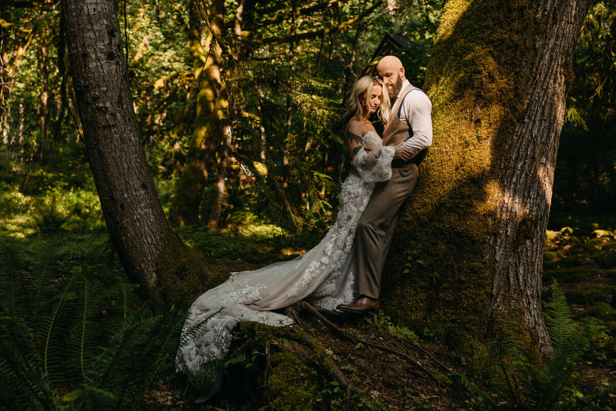 bride and groom standing in the forest