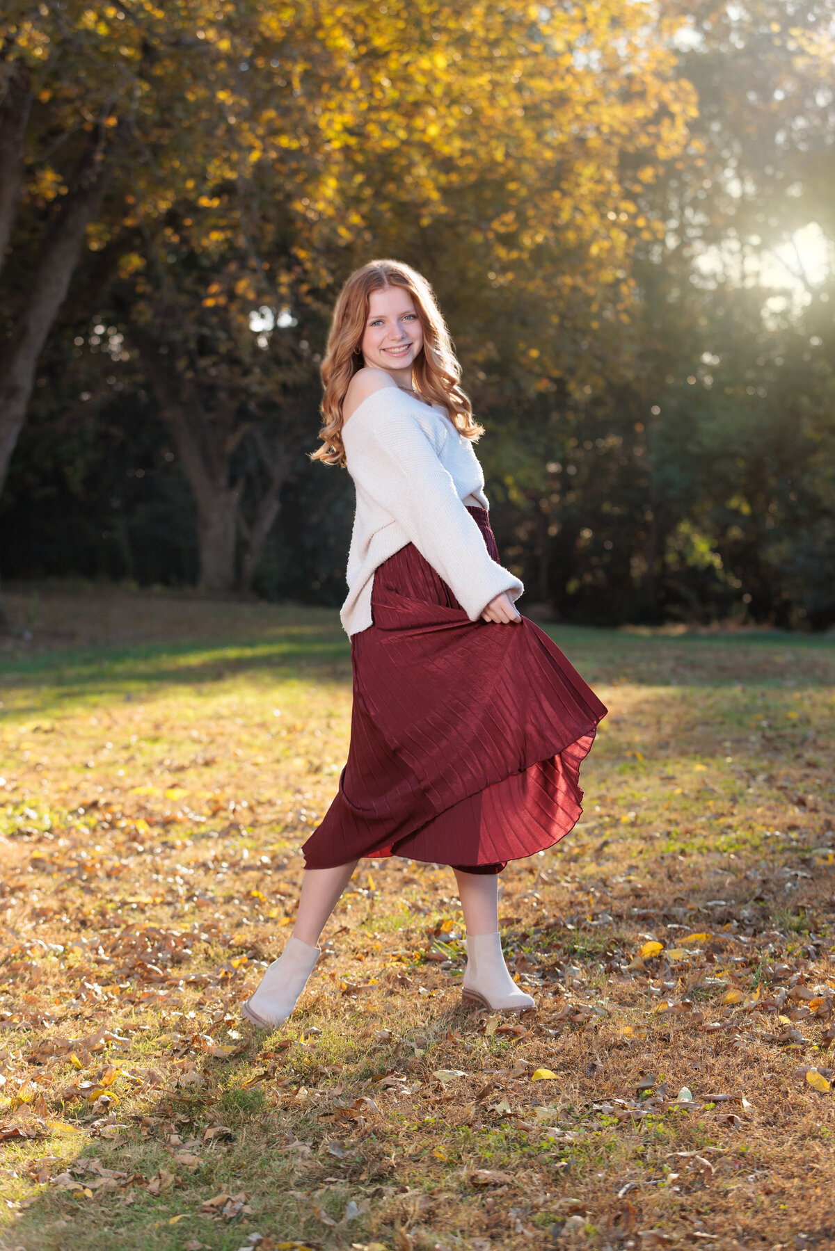 Raleigh Teen Portraits in the fall playing with her skirt at sunset.