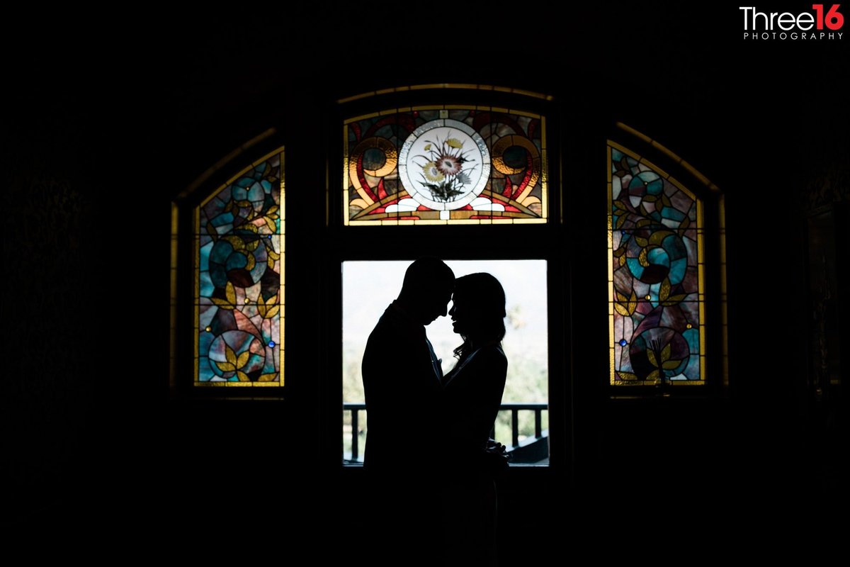 Newly married couple in front a stained glass window