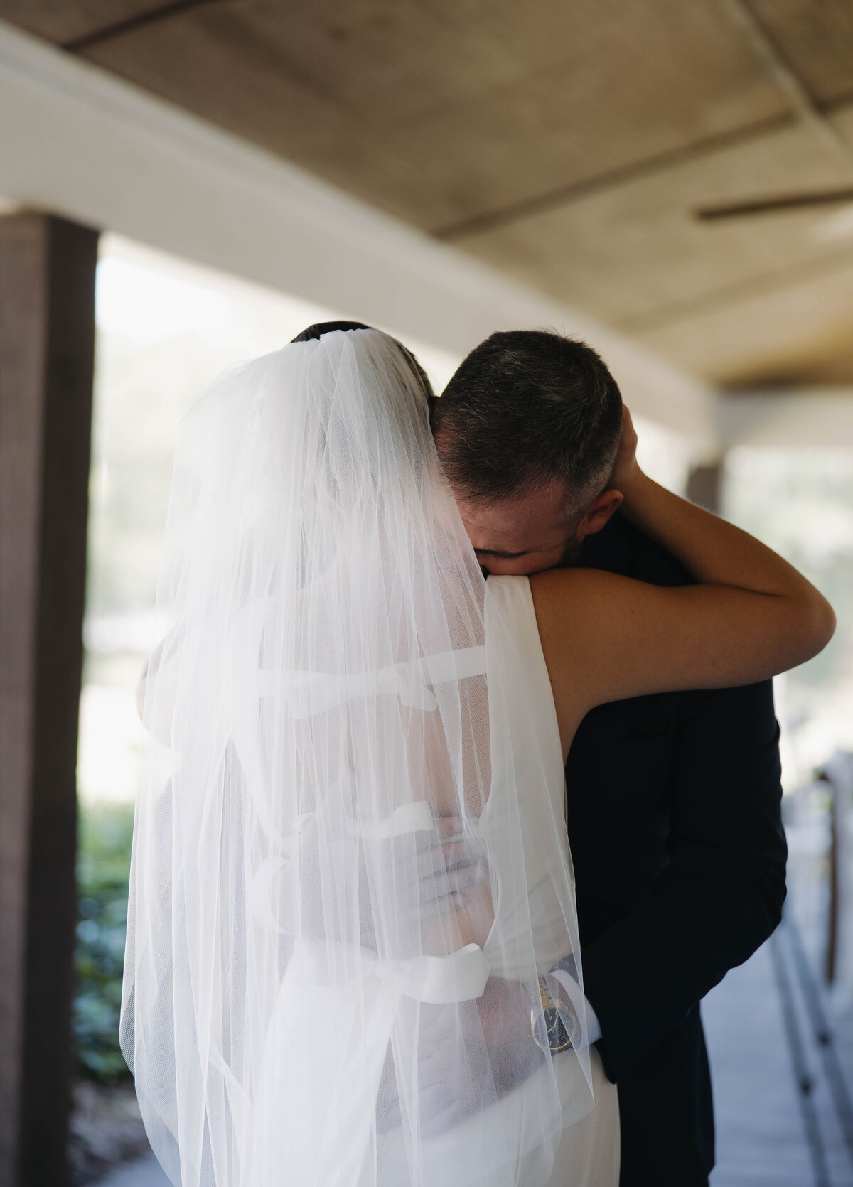 groom crying into brides shoulder after seeing her in her dress