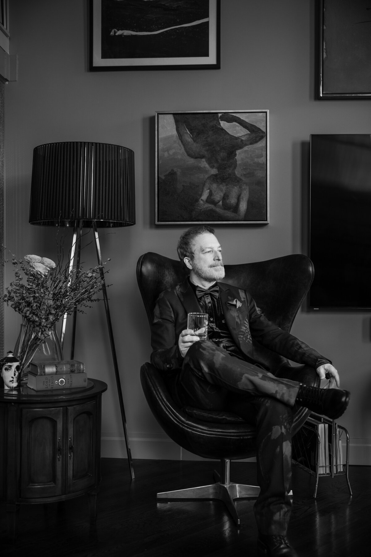 A groom poses in a leather chair before his wedding in Manhattan