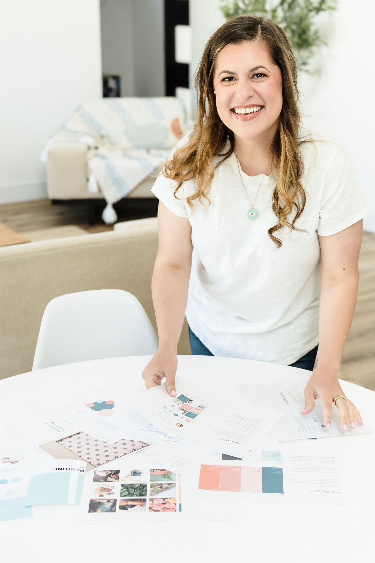 brand photo of a web designer in Sacramento leaning on a table full of inspiration paperwork
