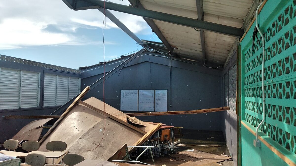 showing torn roof beams and exposed metal supports at barbary hall primary and infant school from hurricane melissa
