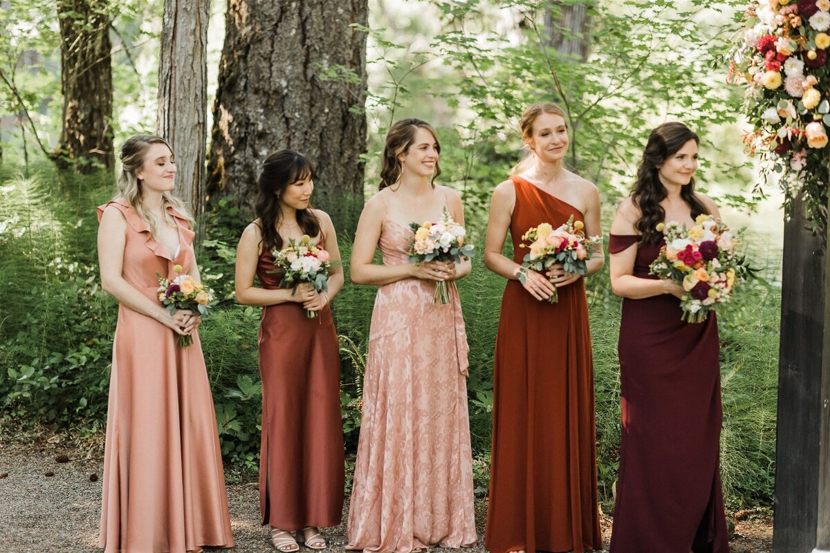 Bridesmaids hold their bouquets during a wedding ceremony.