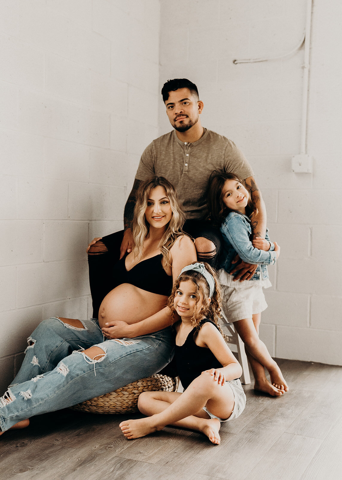 exposed brick family photo in a white studio