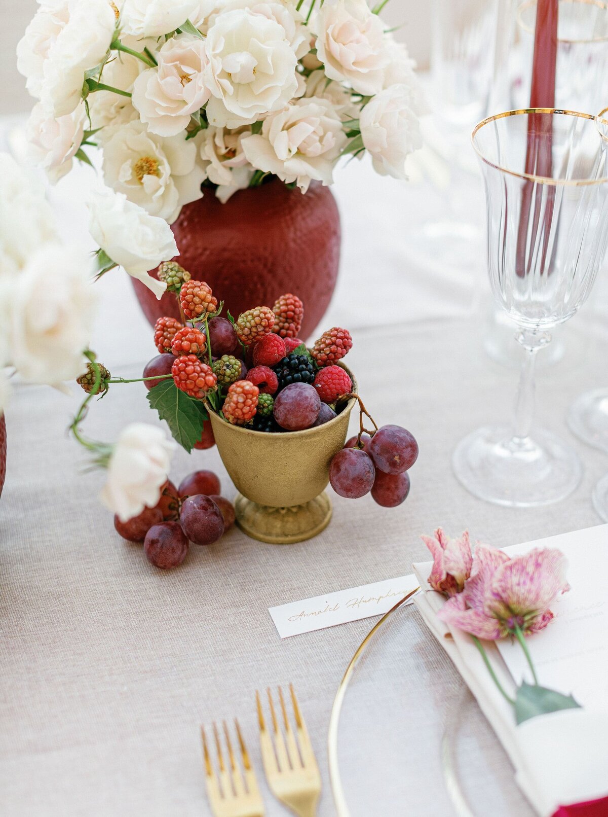 Table-detail-white-flowers-red-vase-berries-gold-rim-plates